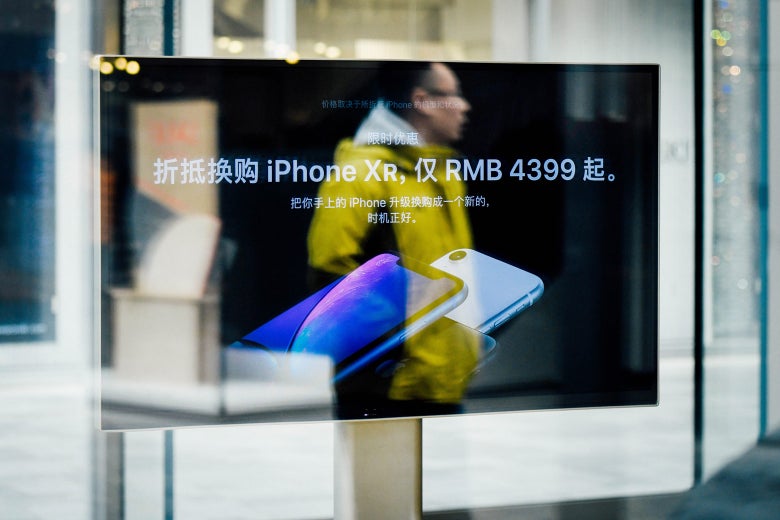 A man is reflected on a screen showing the iPhone XR at an Apple store in Beijing.